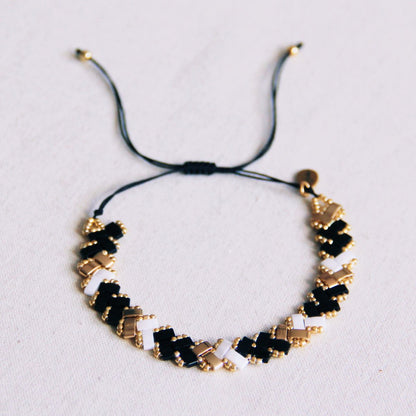 Gevlochten Tila kralenarmband - Zwart/Wit/Goud