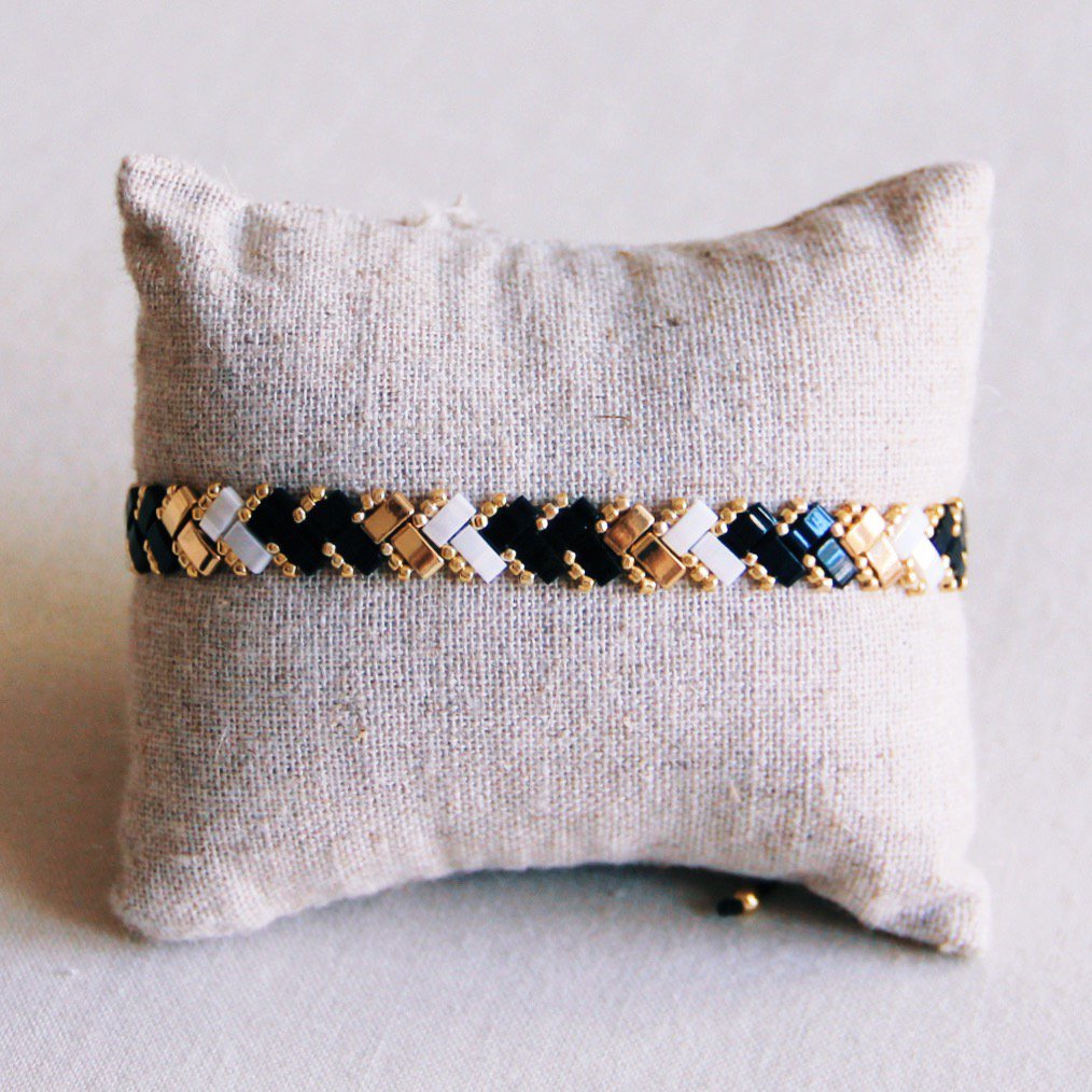 Gevlochten Tila kralenarmband - Zwart/Wit/Goud