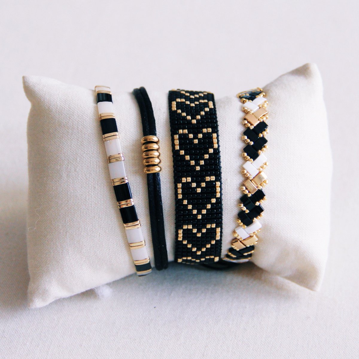 Gevlochten Tila kralenarmband - Zwart/Wit/Goud